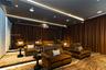 Media room featuring a tray ceiling with recessed lighting, tiered flooring, wall-to-wall drapery, and a ceiling-mounted projector