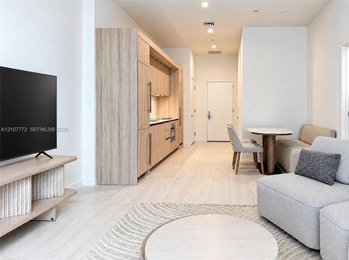 Kitchen featuring flat-panel wood-finish cabinetry, integrated appliances, and recessed lighting throughout