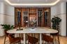 Custom built-in glass-front wine display with integrated accent lighting and natural stone-finish back panel, featuring curved wall detailing and chev