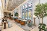 Double-height floor-to-ceiling windows, polished stone flooring, intricate decorative ceiling plasterwork, and recessed cove lighting