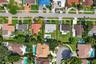 Aerial perspective of a single-family property featuring a rectangular in-ground swimming pool, a fully fenced backyard, and a concrete driveway