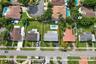 Aerial perspective of a residential property featuring an in-ground swimming pool, a fenced backyard, and a paved driveway