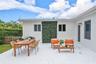 Outdoor patio featuring white brick pavers, a vertical exterior green wall, and a wood picket fence enclosure