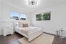 Wood-finish flooring, multi-arm sputnik-style ceiling light fixture, and dual horizontal windows