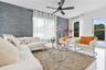 Living space featuring a charcoal-toned stacked stone accent wall, large-format tile flooring, and a modern matte black ceiling fan