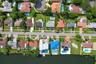 Aerial perspective of a waterfront residential neighborhood featuring multiple properties with private swimming pools and canal access