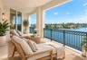 Covered balcony featuring stone-finish flooring, custom metal railing, and direct water exposure