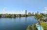 Waterfront property featuring a canal, private swimming pool, mature palm trees, and coastal skyline horizon