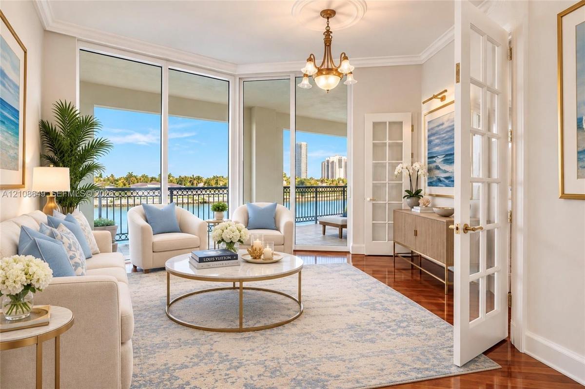 Living area featuring floor-to-ceiling glass sliding doors, polished wood-finish flooring, crown molding, a decorative ceiling medallion with a multi-