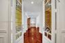 Double doors featuring decorative stained-glass panels, wood-finish flooring laid in a herringbone pattern, wainscoting, and recessed ceiling lighting