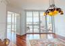 Room featuring wood-finish flooring, wainscoting, intricate crown molding, a decorative metal chandelier, and floor-to-ceiling glass panel doors