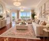 Polished hardwood flooring, crown molding, wainscoting, dual tiered crystal chandeliers, and glass paneled french doors leading to a covered balcony