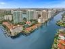 Aerial perspective of waterfront high-rise residential buildings featuring private dockage, clay tile roofing, and expansive water frontage