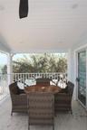 Covered outdoor porch featuring a beadboard ceiling, recessed lighting, a ceiling fan, white metal railing, and light-toned tile flooring