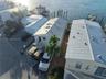 Waterfront property featuring metal roofing, private boat slip, paved driveway, and elevated exterior staircase