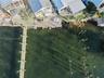 Waterfront property featuring a private boat dock, extended pier, bulkhead hardscaping, and metal roofing