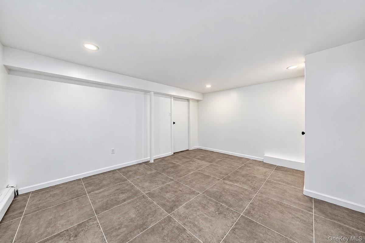 Interior space featuring neutral wall tones, large-format tile flooring, and recessed ceiling lighting