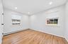 Interior room featuring wood-finish flooring, dual windows with blinds, and recessed lighting