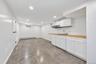 Kitchenette area featuring white shaker-style cabinetry, wood-finish countertops, stainless steel sink, recessed lighting, and tile flooring
