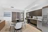 Contemporary kitchen featuring flat-panel cabinetry, stainless steel appliances, subway tile backsplash, recessed lighting, and wood-finish flooring