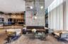 Exposed concrete accent wall with multi-arm fixture, floor-to-ceiling drapery, polished concrete flooring, and decorative brick masonry wall