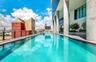 Infinity-edge lap pool featuring integrated structural columns, metal perimeter railing, and built-in landscape planters