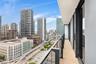 Covered balcony featuring wood-finish flooring, glass panel railings, and metal structural framing