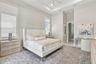High ceilings with a recessed tray detail, large windows with white shutter blinds, and a built-in ceiling fan