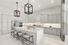 Kitchen featuring shaker-style cabinetry, quartz countertops, a central island, recessed lighting, and geometric pendant fixtures