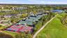 Aerial recreation area featuring multiple tennis courts, pickleball courts, manicured green space, and water features
