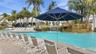 Swimming pool featuring a rock-style waterfall, integrated stone planters, and paved deck surround