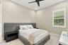 Neutral-toned room featuring a matte black ceiling fan, recessed lighting, and a single window with white plantation shutters