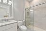 Bathroom featuring a vanity with a light-toned countertop, a frameless glass-enclosed shower with tiled walls and a built-in recessed niche, and polis