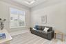 Room interior featuring a tray ceiling, plantation shutters, and neutral wall color