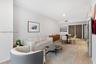 Open-concept interior featuring wood-finish flooring, recessed lighting, and dark-toned interior doors