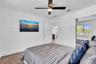 Wood-finish flooring, ceiling fan with integrated lighting, and sliding mirror-paneled closet doors