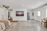 Light-toned tile flooring, recessed ceiling lighting, brushed metallic ceiling fan, stainless steel refrigerator, and wall-mounted climate control uni