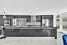 Modern kitchen featuring high-gloss cabinetry, a spacious island with a waterfall edge countertop, mosaic tile backsplash, stainless steel appliances,