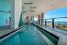 Covered lap pool featuring dark mosaic tile accents, a multi-colored mural wall, recessed ceiling lighting, and a glass panel railing