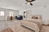 Neutral-toned room featuring stone-finish flooring, recessed lighting, a modern ceiling fan, and a wall-mounted ductless heating and cooling unit