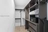 Custom closet system featuring dark wood-finish cabinetry, integrated shelving, hanging rods, and two soft-close drawers, complemented by wood-finish 