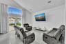 Vaulted ceilings, large-format tile flooring, recessed lighting, and expansive floor-to-ceiling glass panel doors