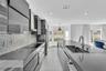 Modern kitchen featuring high-gloss cabinetry, stone countertops, a mosaic tile backsplash, a stainless steel range hood, and a large central island w