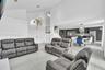 Vaulted ceilings, large-format tile flooring, a built-in staircase with a metal railing, recessed lighting, and a modern kitchen featuring a central i