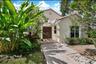 Stucco on concrete exterior featuring a tiled roof, paver stone walkway, double entry doors, and overhead trellis. Built on concrete slab no crawl spa
