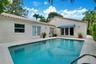 In-ground swimming pool with a concrete surround, tile roof, and multiple glass-paned double doors