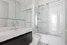 Modern vanity with integrated rectangular basin and polished chrome widespread faucet, mirrored medicine cabinet, floor-to-ceiling tiled shower enclos