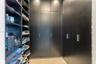 Custom black cabinetry featuring floor-to-ceiling storage, sleek metallic hardware, and integrated open shelving