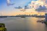 Expansive water frontage featuring a panoramic cityscape, marina docks, and coastal greenery