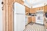 Another view, showing the pantry, dishwasher, range/oven and microwave.